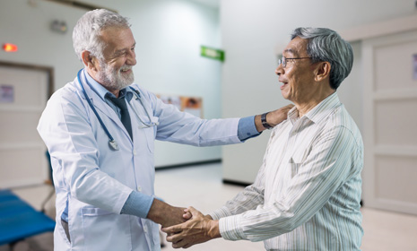 Doctor greeting elderly patient in clinic